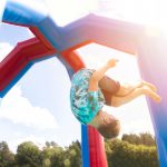 The joyful world of jumping castles. Why renting an inflatable for your event is a great idea.. In an inflatable jumping castle, a young boy is seen inverted.