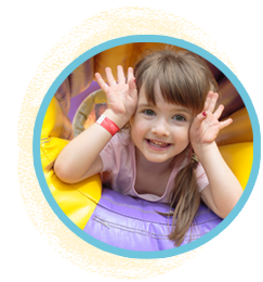 Bouncy castle rentals. A cheerful young girl wearing a smile, enjoying herself in a vibrant purple and yellow bouncy castle.