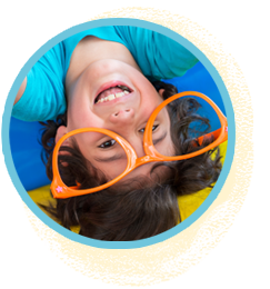 Bouncy castle rentals. A smiling child with orange glasses, radiating joy and happiness.